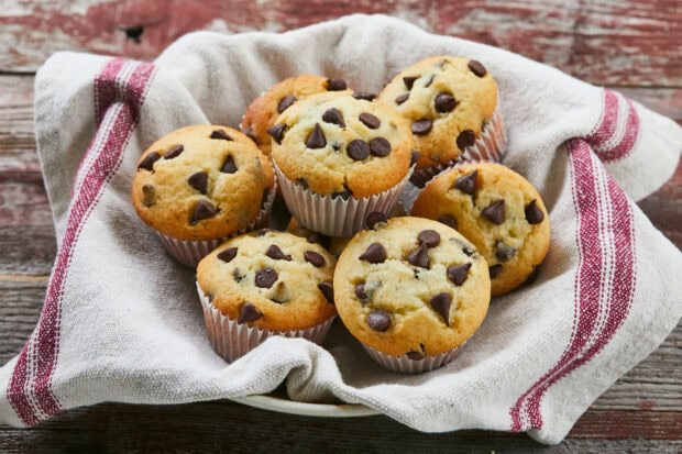 Chocolate chip muffin arranged in a basket with a cloth lining