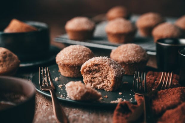 A fresh batch of homemade muffins with sugar coating on a dark plate