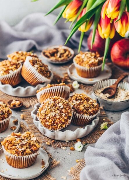 A close up of healthy muffin topped with oats and nuts on a plate