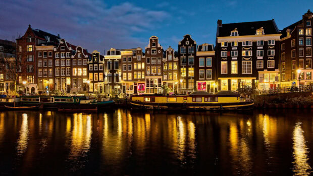 Historic canal houses reflection in the water in a Netherlands city at night