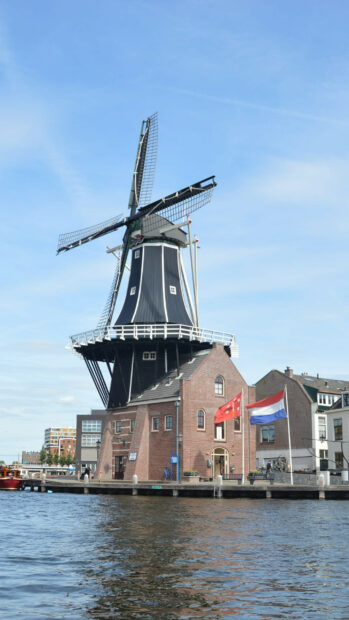 A traditional Dutch windmill and brick building by the water in Netherlands