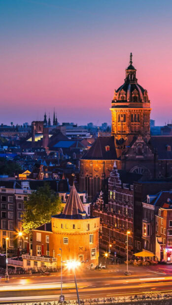 Historic tower illuminated at dusk in Netherlands cityscape