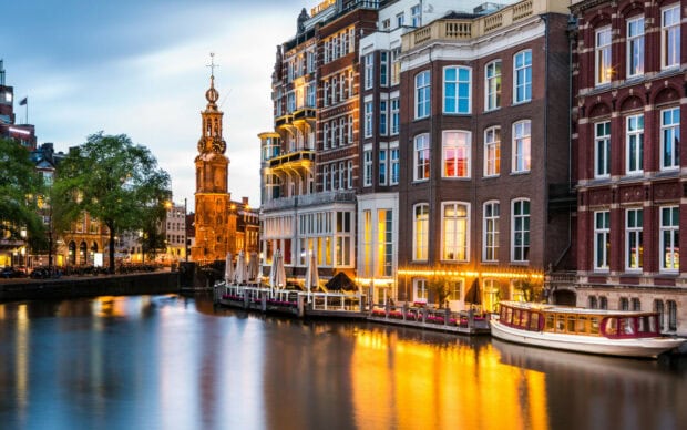 Historic buildings along the canal in a Netherlands cityscape at dusk