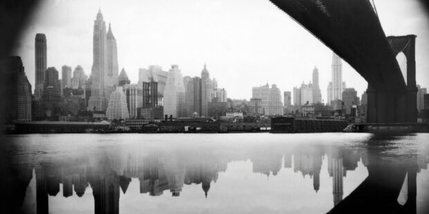Vintage New York skyline with bridge reflected in water showing classic cityscape