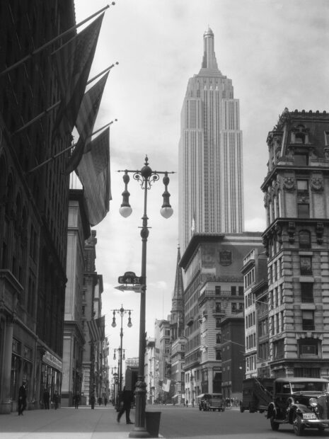 Vintage New York street scene with Empire State Building and American flags in black and white