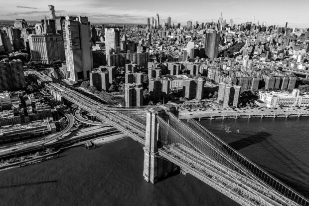 Black and white view of New York cityscape with Brooklyn Bridge and buildings