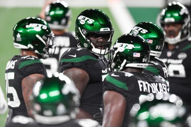 New York Jets players huddling on the football field during a game session