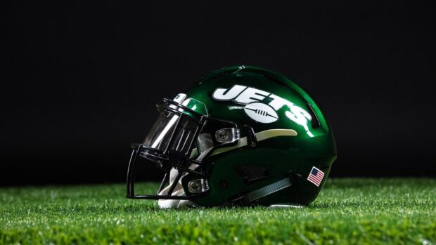 Green New York Jets helmet resting on grass with American flag sticker