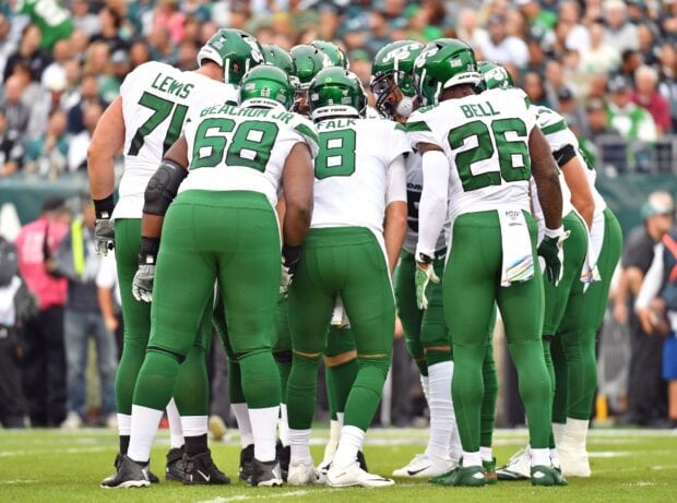 New York Jets huddle up during a game showing players in green and white uniforms