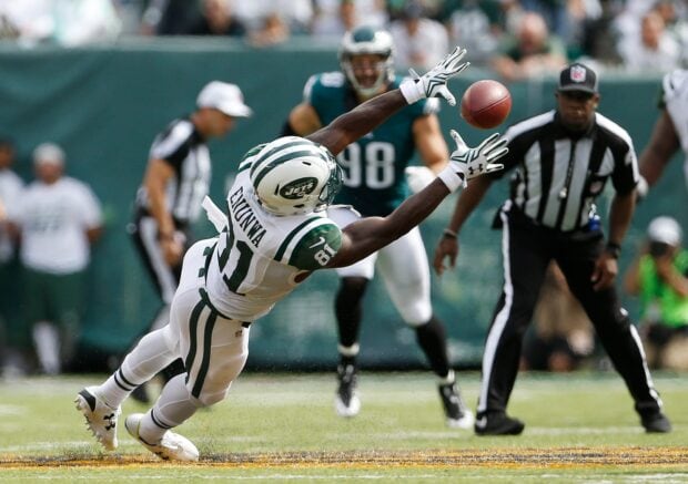New York Jets player diving to catch the football during a game