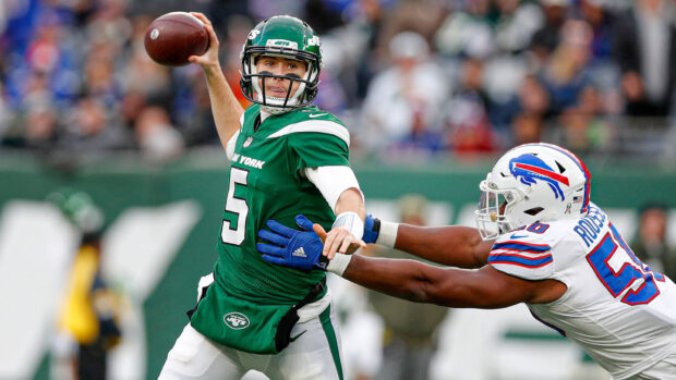 New York Jets player preparing to throw a football during a game against the opposing team