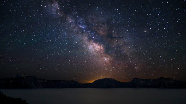 Night skyline with stars and milky way over mountain silhouettes