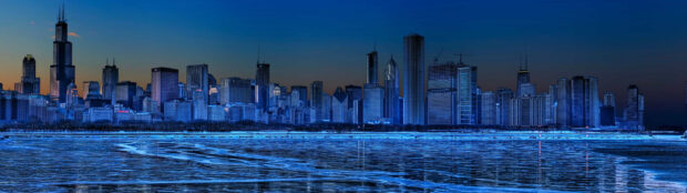 A vibrant night skyline with tall buildings reflecting on a frozen lake in a major cityscape