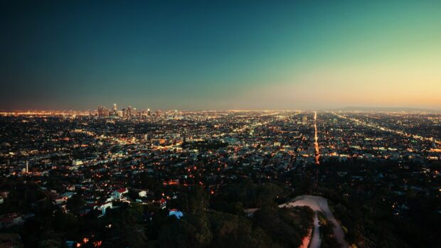 A vast night skyline with city lights stretching to the horizon and a clear evening sky