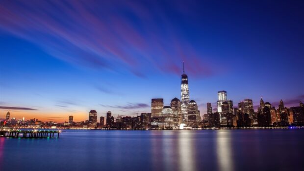 Beautiful night skyline with city lights reflecting on the calm water surface