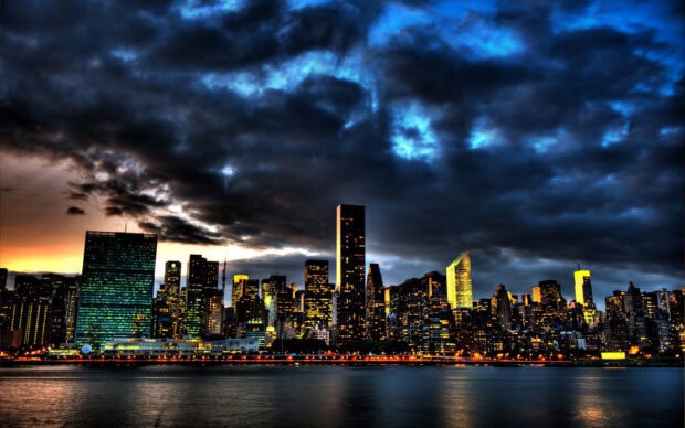 Stunning cityscape with night skyline illuminated by colorful lights and dramatic clouds