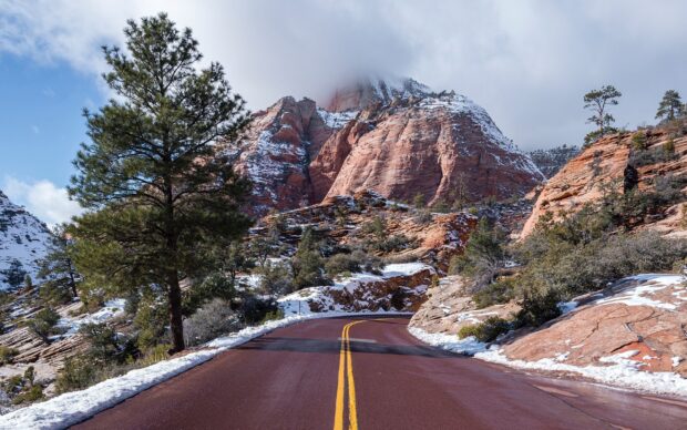 Snow covered mountains and trees along a winding road in North America