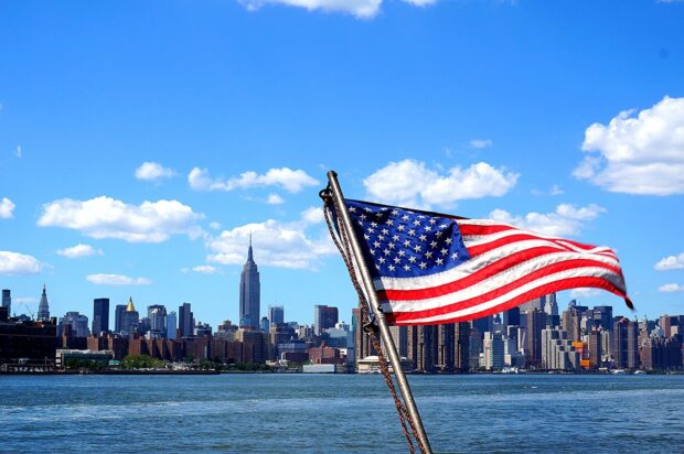 American flag waving with New York City skyline in North America