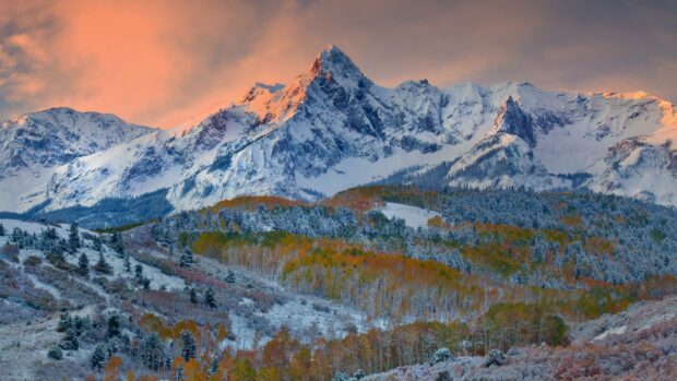 Snowy mountain peaks with colorful autumn forest in North America landscape
