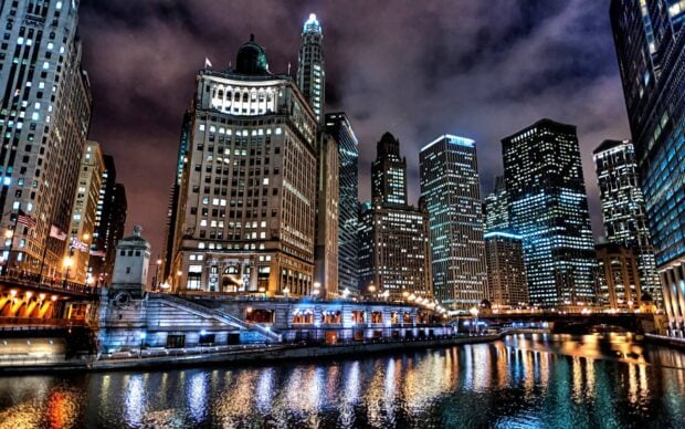 Chicago cityscape at night with illuminated buildings and river reflections