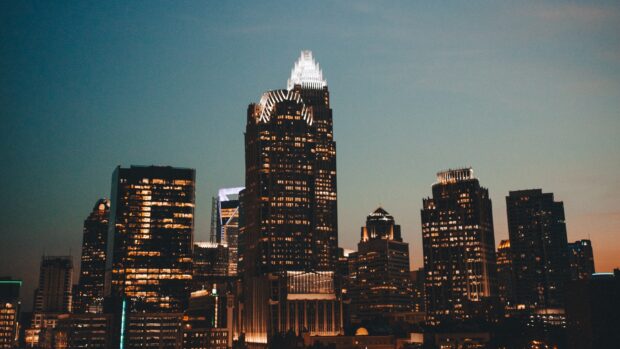 The North Carolina skyline at dusk with illuminated skyscrapers and a clear evening sky
