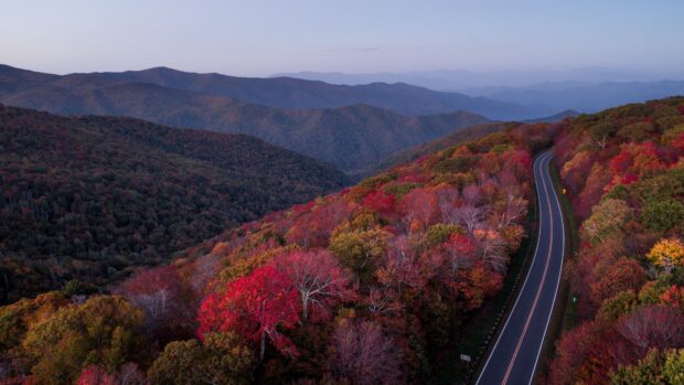 A scenic view of North Carolina mountains with colorful autumn trees and a winding road