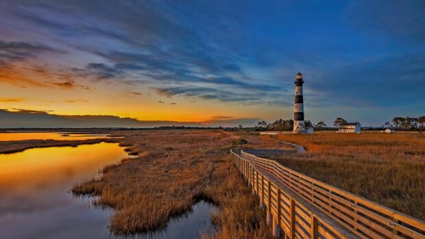 A beautiful North Carolina marshland with a lighthouse at sunset on a clear sky