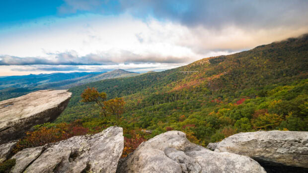 Autumn foliage and rocky cliffs overlook forested hills in North Carolina