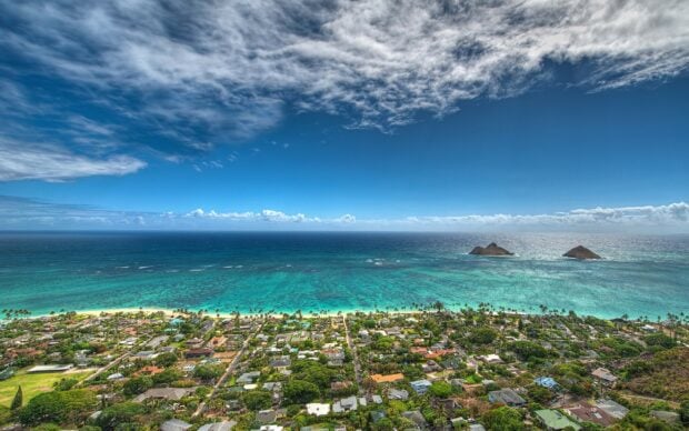 Aerial view of Oahu coastline and ocean with clear blue sky and distant islands