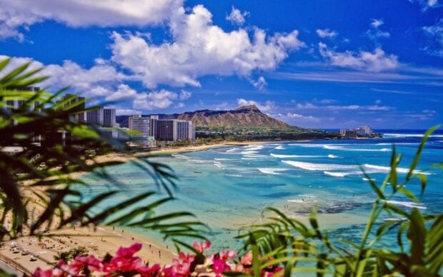 View of Oahu coastline with Diamond Head volcano and turquoise water under a blue sky