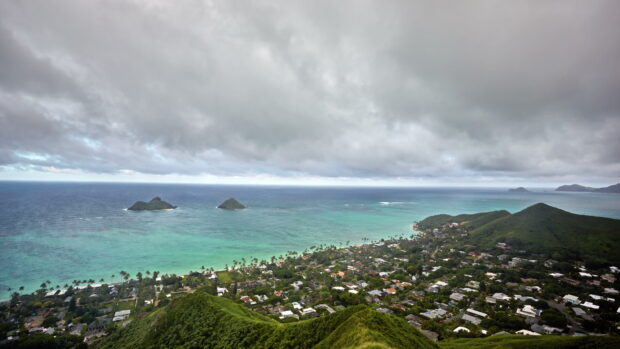 Aerial view of Oahu with ocean and islands under cloudy sky