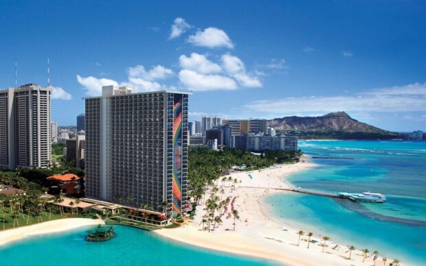 A vibrant cityscape of Oahu with clear blue skies and the famous Diamond Head mountain visible