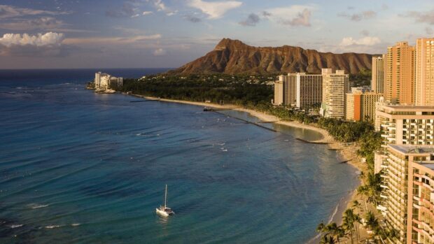 A beautiful sunrise view of Oahu coastline with Diamond Head mountain and clear ocean water