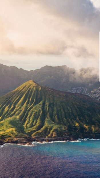 A scenic view of Oahu coastline with lush green mountains and blue ocean