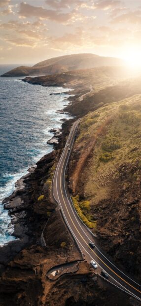 Winding coastal road in Oahu with ocean views at sunset