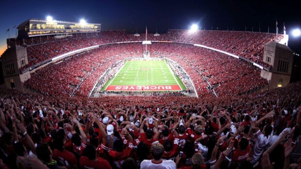 A large crowd cheering at the Ohio stadium during a night football game