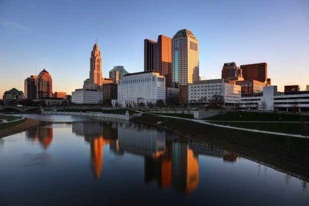 Stunning Ohio cityscape reflecting on calm river during sunset light