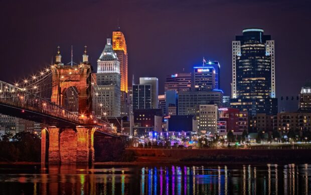 The Cincinnati skyline with the illuminated John A Roebling Suspension Bridge at night in Ohio