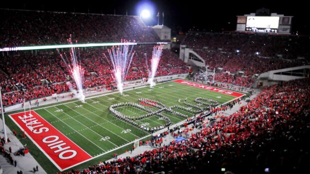 A marching band forming the word Ohio on a football field during a game in Ohio State Stadium