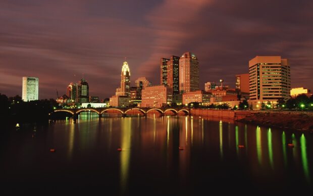 The Ohio cityscape at night with illuminated buildings and a bridge over the river