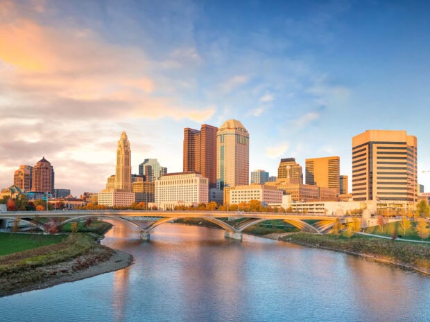 A beautiful view of Ohio skyline with modern buildings and a river under a colorful sky