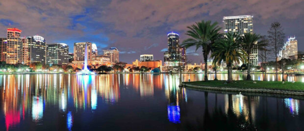 Orlando skyline at night with illuminated buildings and water reflections