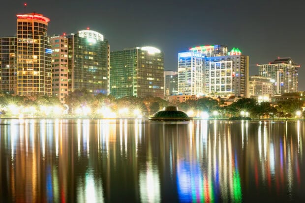 Orlando skyline at night with illuminated buildings reflecting on the lake water