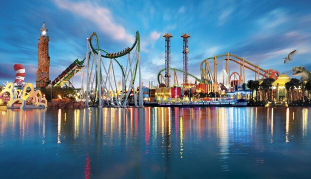 Orlando skyline with amusement park rides reflected on calm water at dusk
