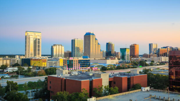 Orlando skyline with tall buildings under a clear blue sky at sunset