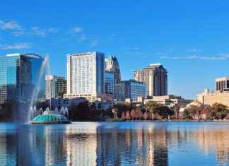 Modern buildings reflecting in the lake of Orlando skyline with a blue sky