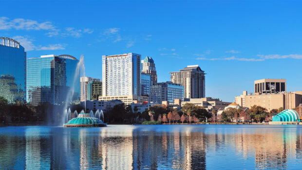 Modern buildings reflecting in the lake of Orlando skyline with a blue sky