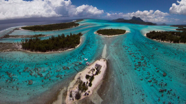 Aerial view of a tropical island with turquoise Pacific Ocean waters and lush greenery