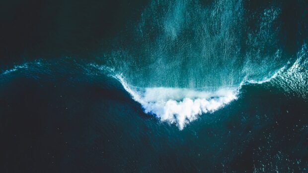 Aerial view of Pacific Ocean waves crashing and creating white foam patterns