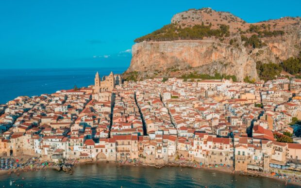 Aerial view of Palermo town with historic buildings and mountain cliffs near the sea